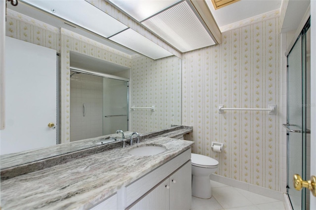 bathroom with wallpapered walls, toilet, vanity, a shower stall, and tile patterned floors