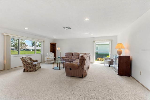 carpeted living area with a healthy amount of sunlight, visible vents, and recessed lighting