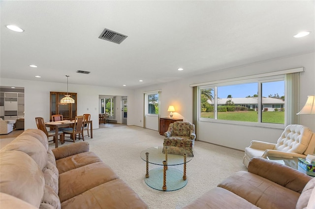 living area with light carpet, baseboards, visible vents, and recessed lighting