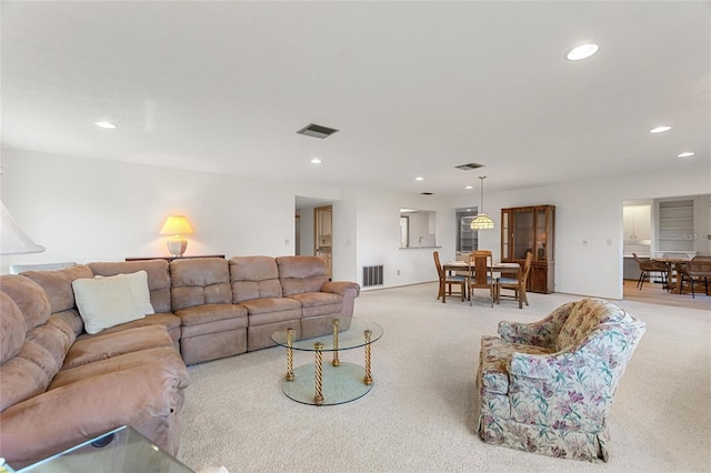 living room featuring recessed lighting, visible vents, and light colored carpet