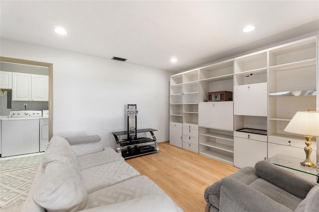 living room with light wood-type flooring, visible vents, washer and dryer, and recessed lighting