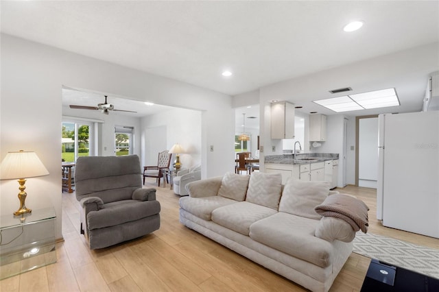 living area featuring light wood-style flooring, visible vents, and recessed lighting