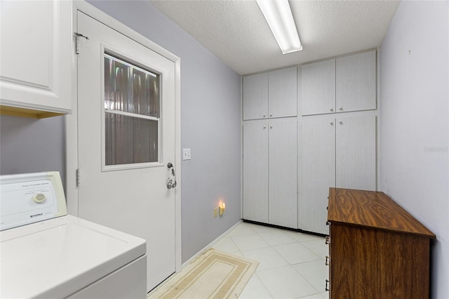 washroom with washer / dryer, cabinet space, and a textured ceiling