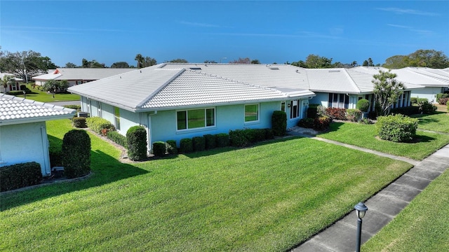 single story home featuring stucco siding, a tiled roof, and a front yard