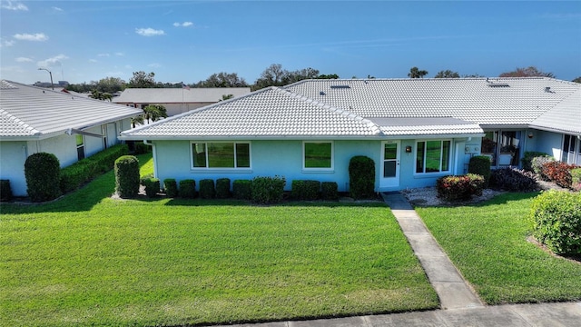 ranch-style house with a front lawn, a tile roof, and stucco siding