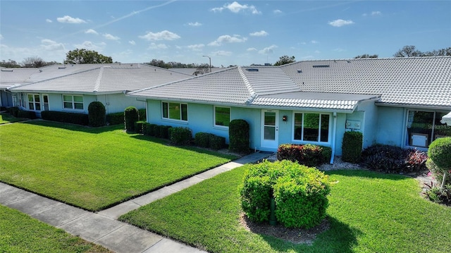 single story home featuring stucco siding, a tile roof, and a front yard