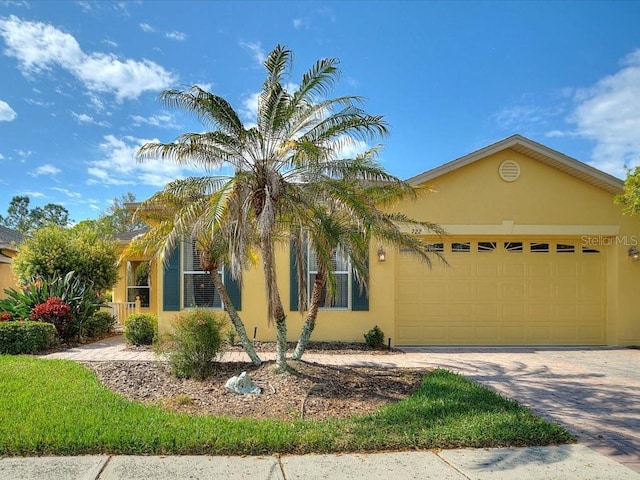 view of front of home featuring stucco siding, an attached garage, and driveway