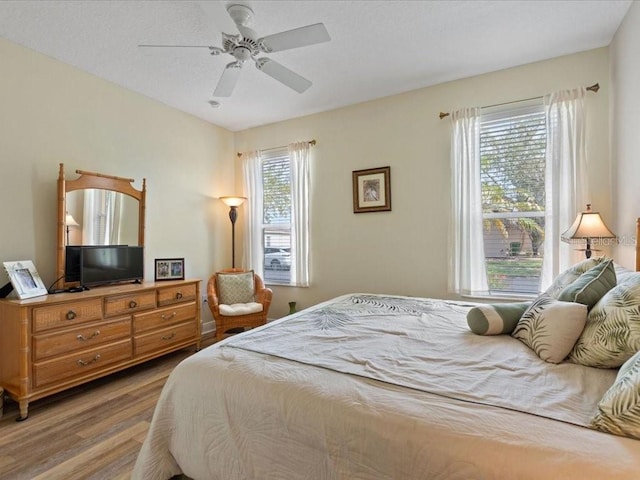 bedroom featuring a textured ceiling, wood finished floors, and ceiling fan