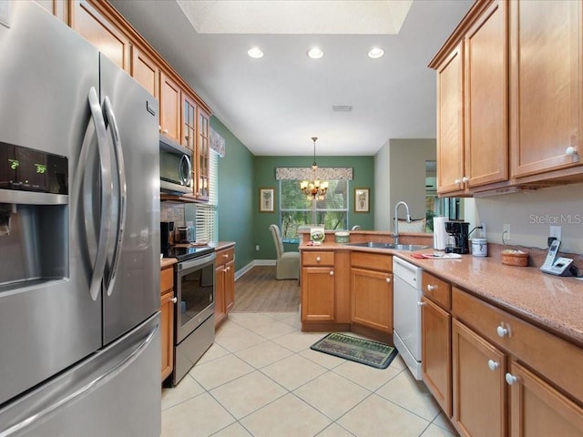 kitchen featuring visible vents, a sink, appliances with stainless steel finishes, a peninsula, and light tile patterned floors