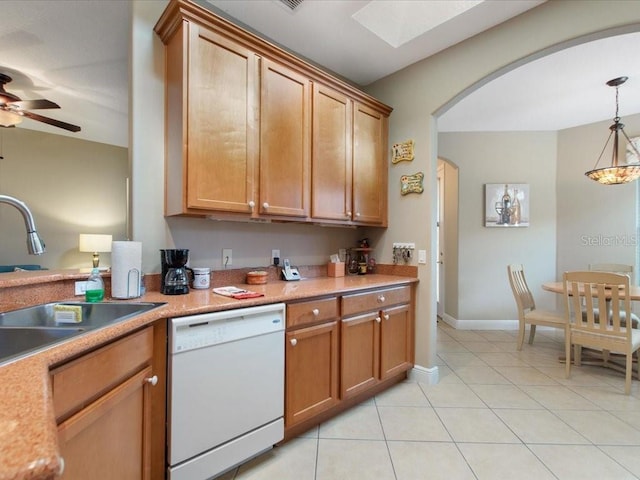 kitchen with arched walkways, light tile patterned floors, dishwasher, and light countertops