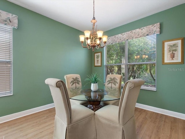 dining area with an inviting chandelier, wood finished floors, and baseboards