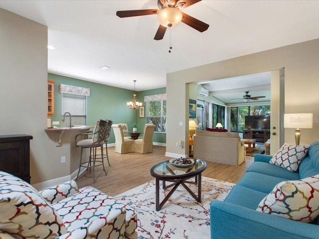 living area with a wall mounted air conditioner, plenty of natural light, and light wood finished floors