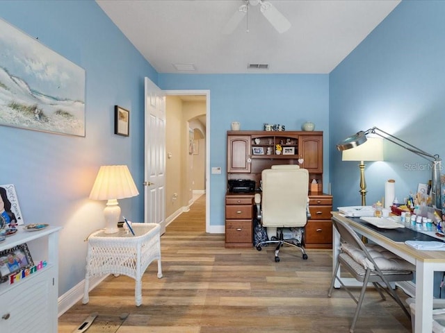 office featuring visible vents, baseboards, ceiling fan, and light wood finished floors