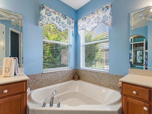 full bathroom with a ceiling fan, a garden tub, and vanity