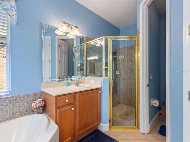 bathroom featuring tile patterned floors, a stall shower, vanity, and a garden tub