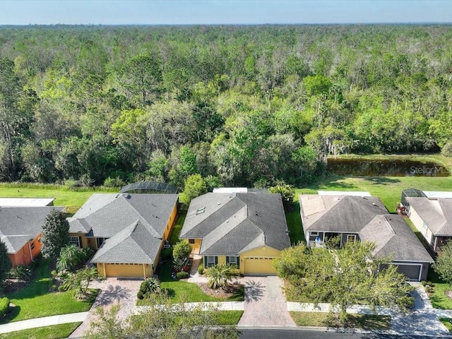 aerial view featuring a wooded view and a residential view