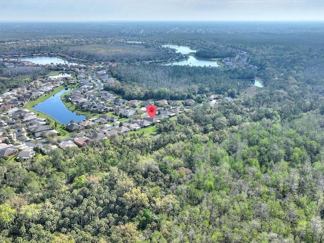 birds eye view of property with a residential view, a view of trees, and a water view