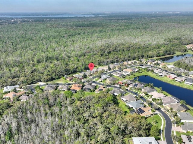 drone / aerial view with a residential view, a view of trees, and a water view