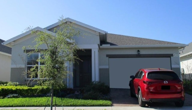 single story home featuring a garage, driveway, a shingled roof, and stucco siding