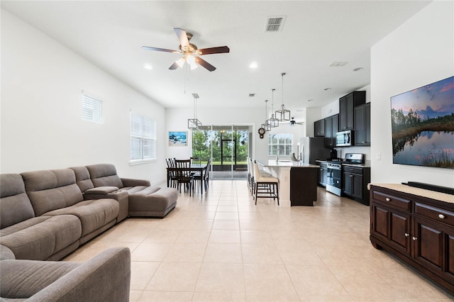 living room with light tile patterned floors, visible vents, a ceiling fan, and recessed lighting