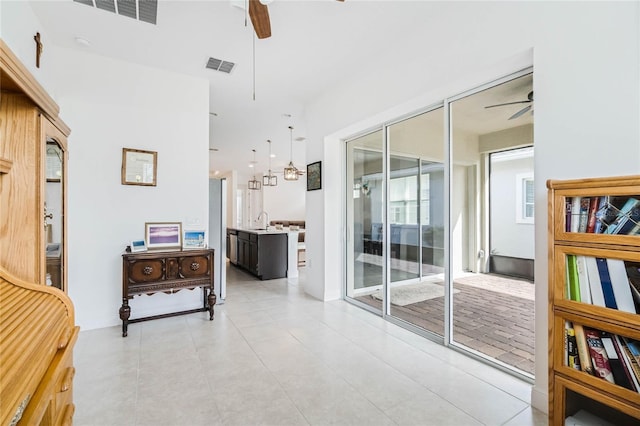 hall featuring a sink, visible vents, and light tile patterned floors