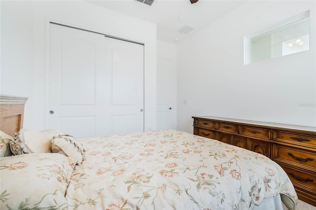 bedroom with a closet, visible vents, and ceiling fan