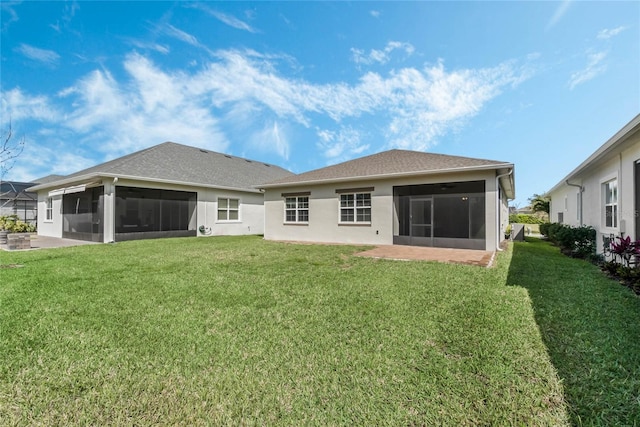 back of house featuring a patio area, stucco siding, a lawn, and a sunroom