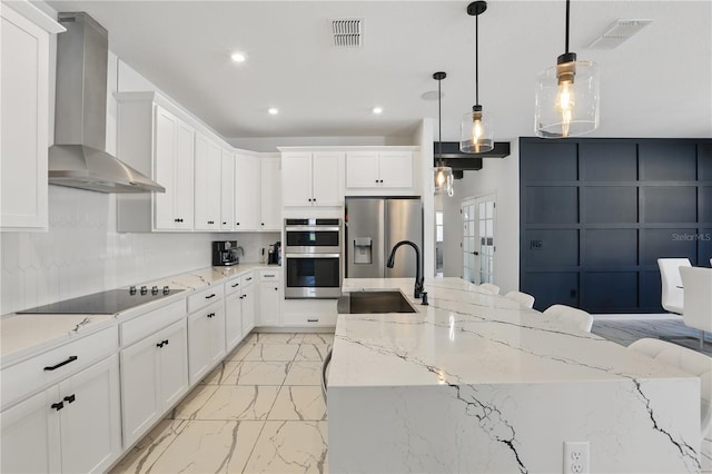 7793 Clove Hitch Way, Orlando, FL 32832 - kitchen featuring marble finish floor, stainless steel appliances, visible vents, a sink, and wall chimney range hood