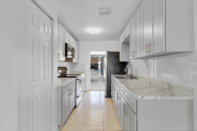 kitchen with stainless steel appliances, light countertops, visible vents, light tile patterned flooring, and a sink