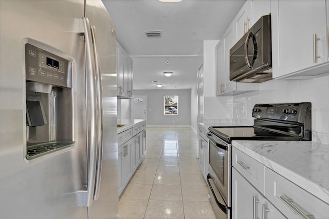 kitchen with light tile patterned flooring, visible vents, white cabinetry, appliances with stainless steel finishes, and tasteful backsplash