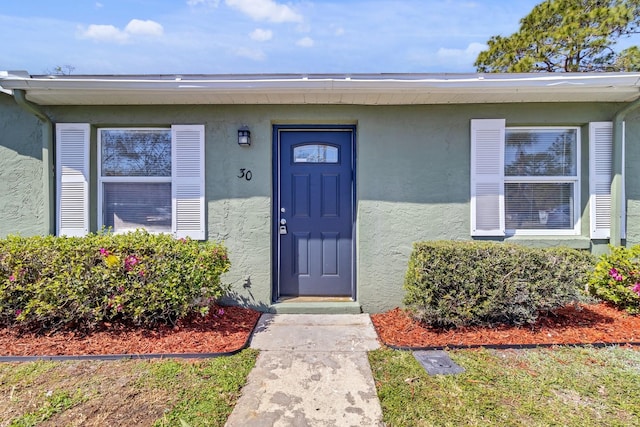 entrance to property with stucco siding