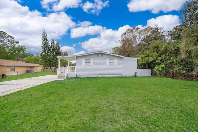 view of front of house with driveway, fence, a carport, and a front yard