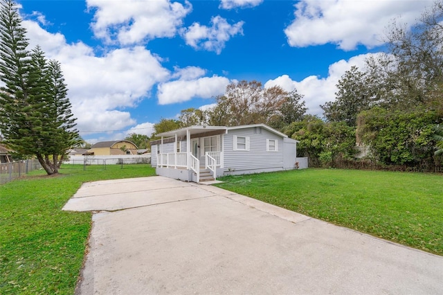 manufactured / mobile home featuring a front lawn and fence