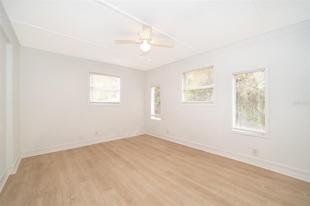 unfurnished room featuring light wood finished floors, a wealth of natural light, and baseboards