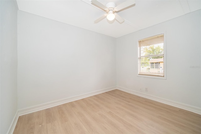 empty room featuring baseboards, a ceiling fan, and light wood-style floors