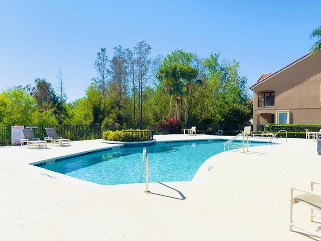 community pool featuring a patio area and fence