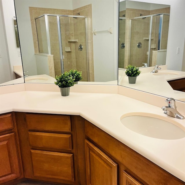 bathroom with double vanity, a stall shower, and a sink