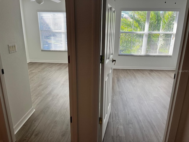 spare room with baseboards and wood finished floors