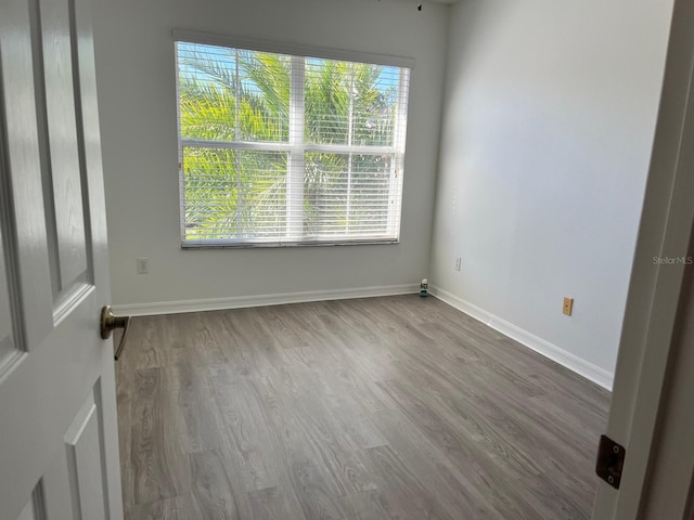 unfurnished room with baseboards and wood finished floors