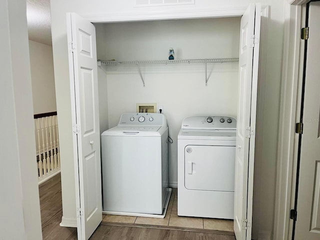 laundry area with light wood-style floors, washer and dryer, and laundry area