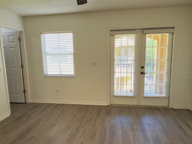 interior space with french doors, wood finished floors, a ceiling fan, and baseboards