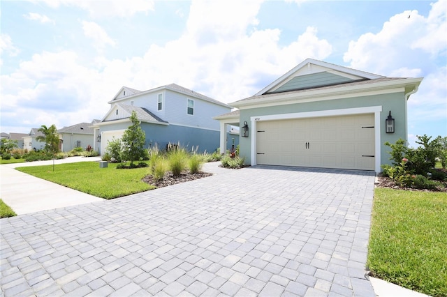 view of front of property featuring a front yard, decorative driveway, an attached garage, and stucco siding