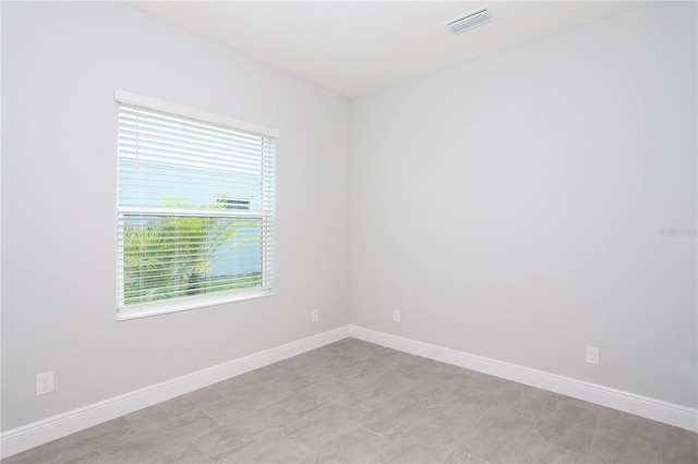 spare room with baseboards and visible vents