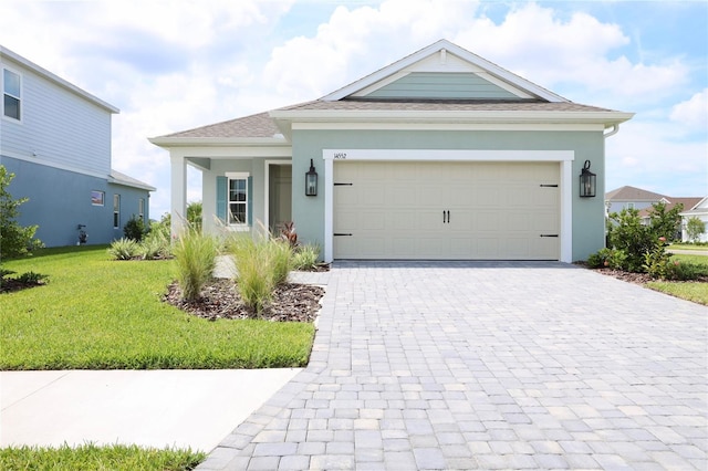 ranch-style home featuring an attached garage, a front lawn, decorative driveway, and stucco siding