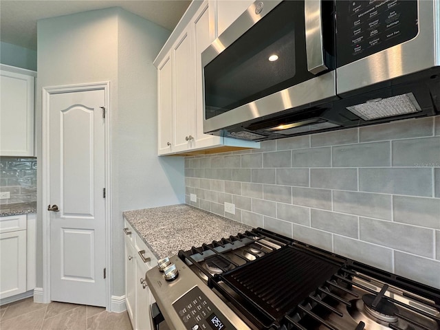 14552 Skipping Stone Loop, Parrish, FL 34219 - kitchen featuring appliances with stainless steel finishes, white cabinets, backsplash, and light stone counters