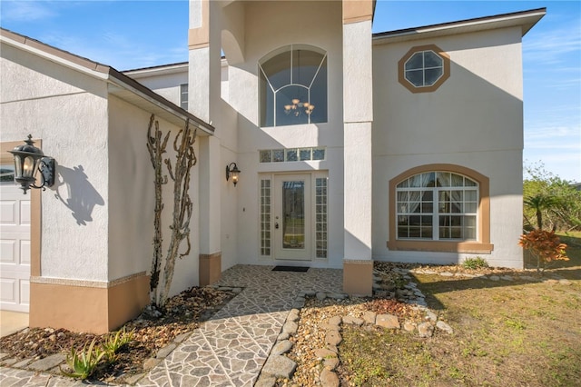 entrance to property with stucco siding and a garage