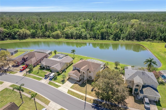 bird's eye view featuring a residential view, a wooded view, and a water view