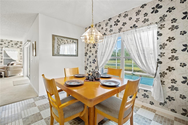 dining room with a notable chandelier, a textured ceiling, and wallpapered walls