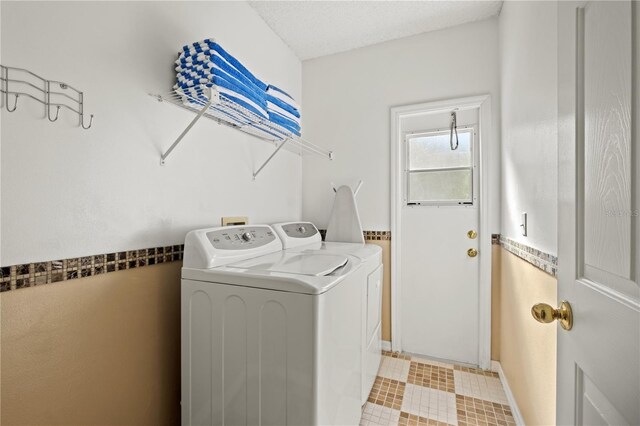 laundry area featuring laundry area, washing machine and dryer, and a textured ceiling