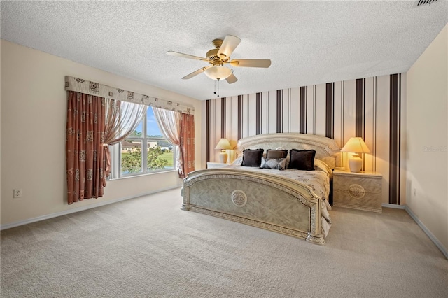 carpeted bedroom with a textured ceiling, wallpapered walls, baseboards, and a ceiling fan